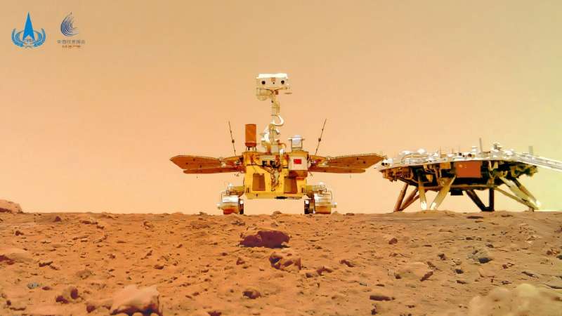 Hello there: an image of the Zhurong rover rolling around the red surface. Hello there: an image of the Zhurong rover rolling around the red surface
